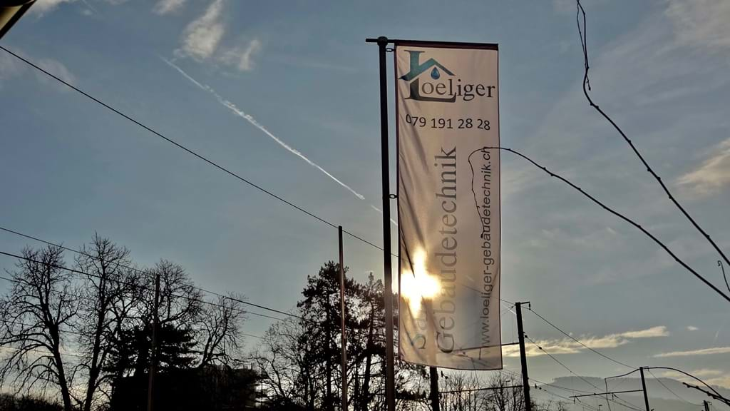 Fahne und Logo der Loeliger Gebäudetchnik mit Sonne im Hintergrund